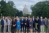 a group of people posing for a photo in front of a capitol building