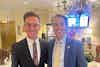 two men in suits smiling for a picture